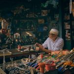 Comerciante organiza ferramentas em uma loja de ferragens.