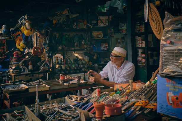 Comerciante organiza ferramentas em uma loja de ferragens.