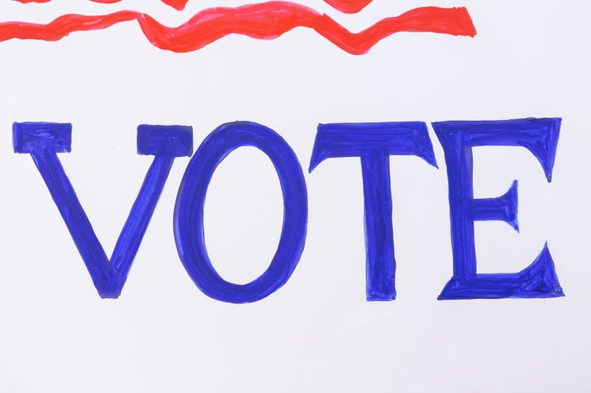 Placa azul com a palavra “VOTE” em destaque, simbolizando a participação nas eleições.