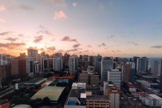 Vista aérea do bairro Meireles, em Fortaleza, com a orla urbana ao entardecer.