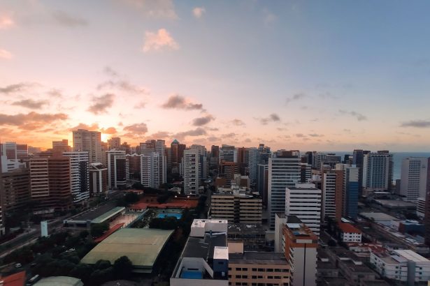Vista aérea do bairro Meireles, em Fortaleza, com a orla urbana ao entardecer.