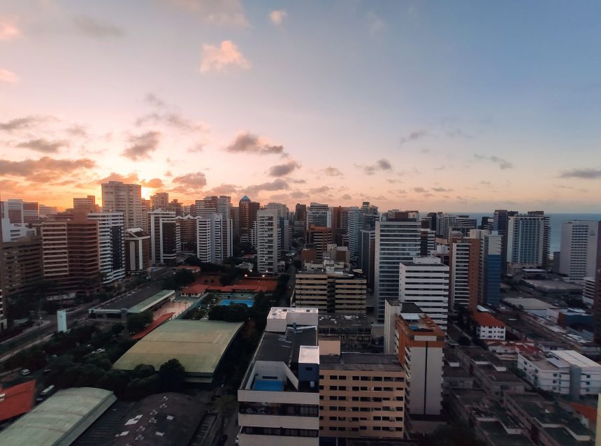 Vista aérea do bairro Meireles, em Fortaleza, com a orla urbana ao entardecer.